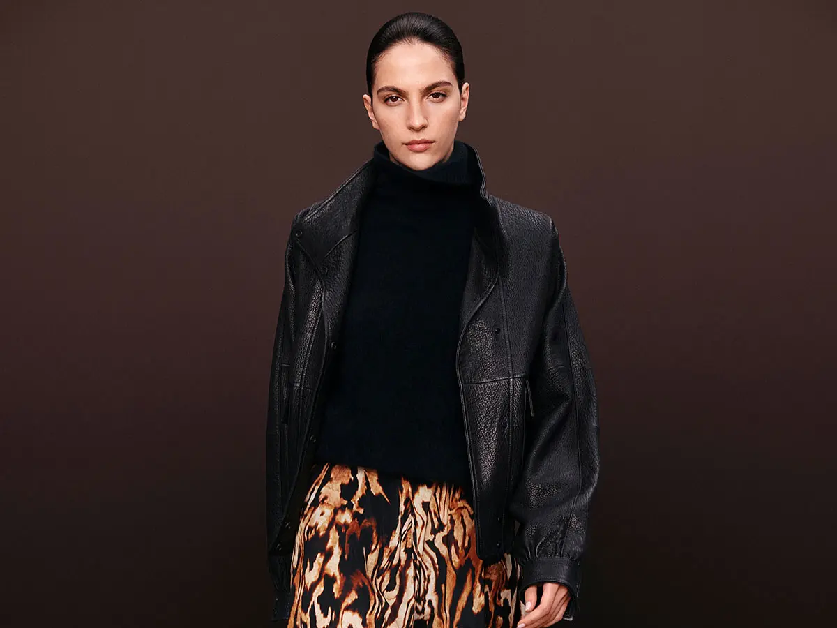 Woman wearing black leather jacket with printed skirt