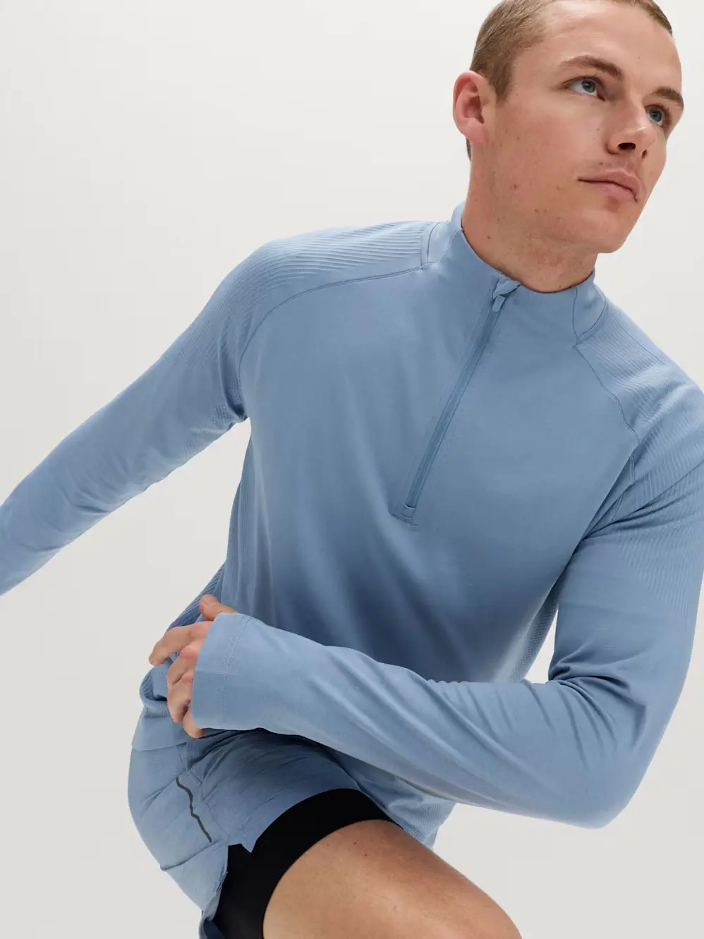 Man in light blue long-sleeve top and shorts