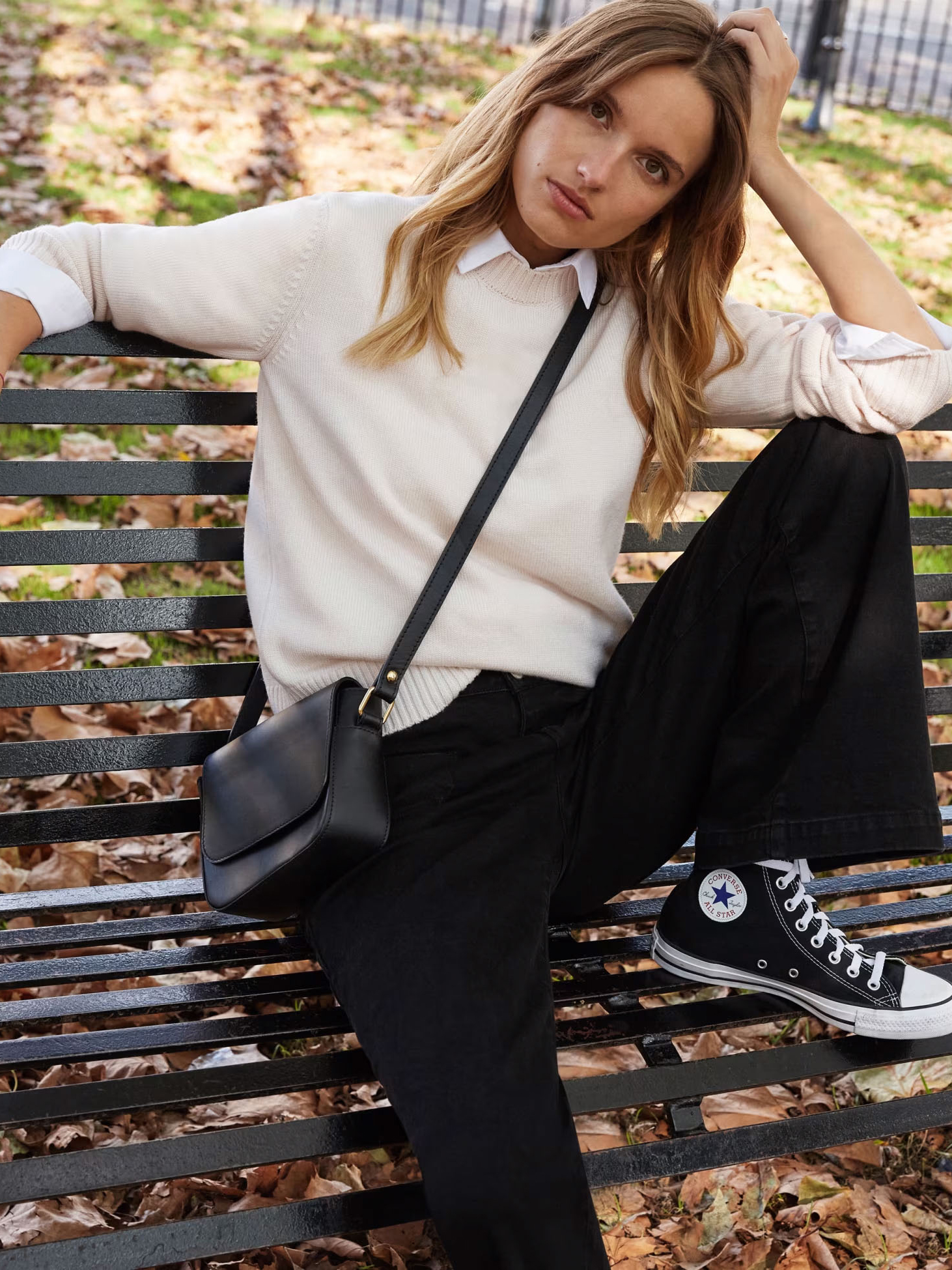 Woman wearing cream jumper and black wide-leg jeans. Shop wide-leg jeans