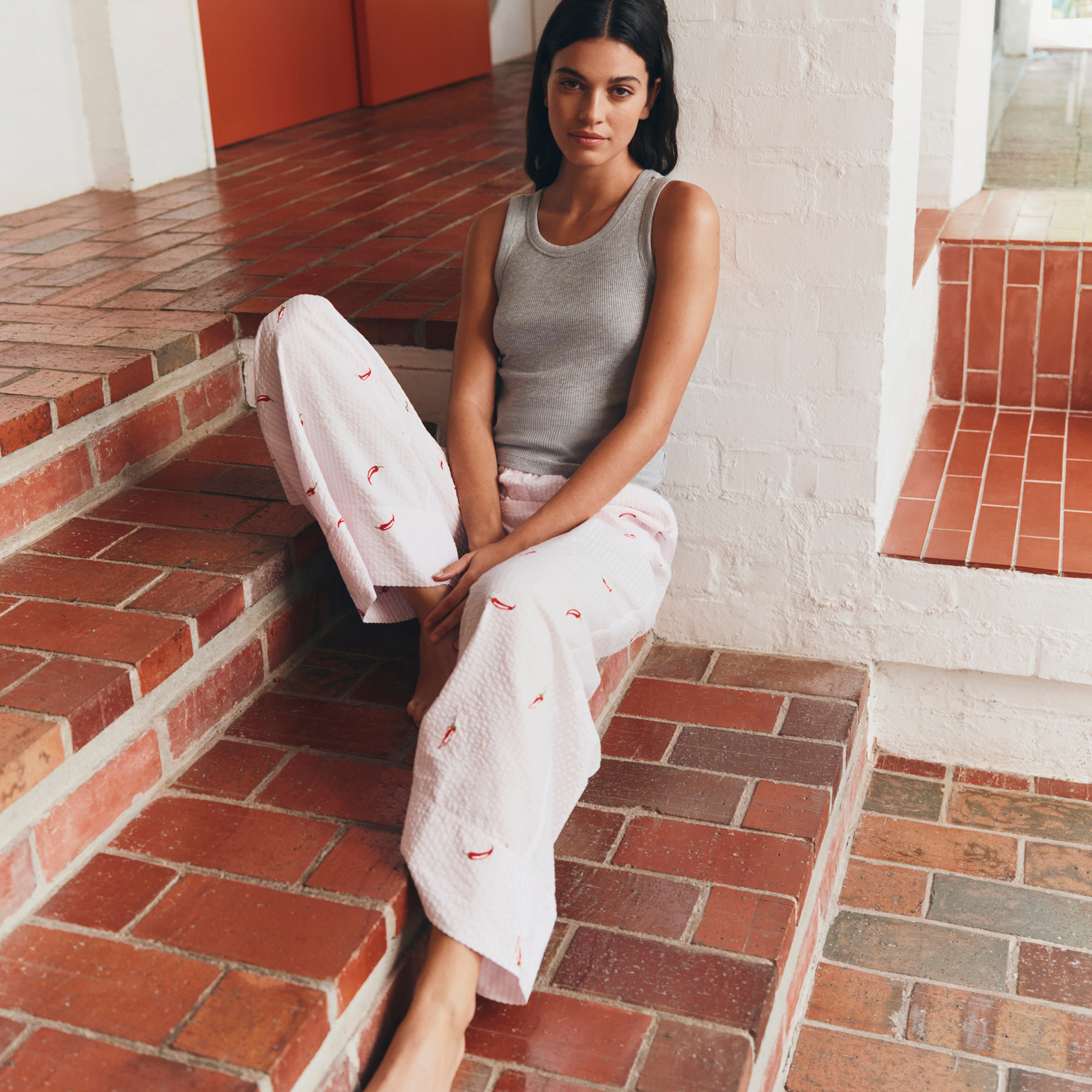 Woman sitting on step in pyjamas