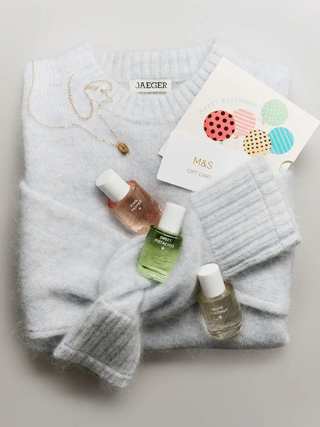 Jumper folded with perfume bottles and gift card