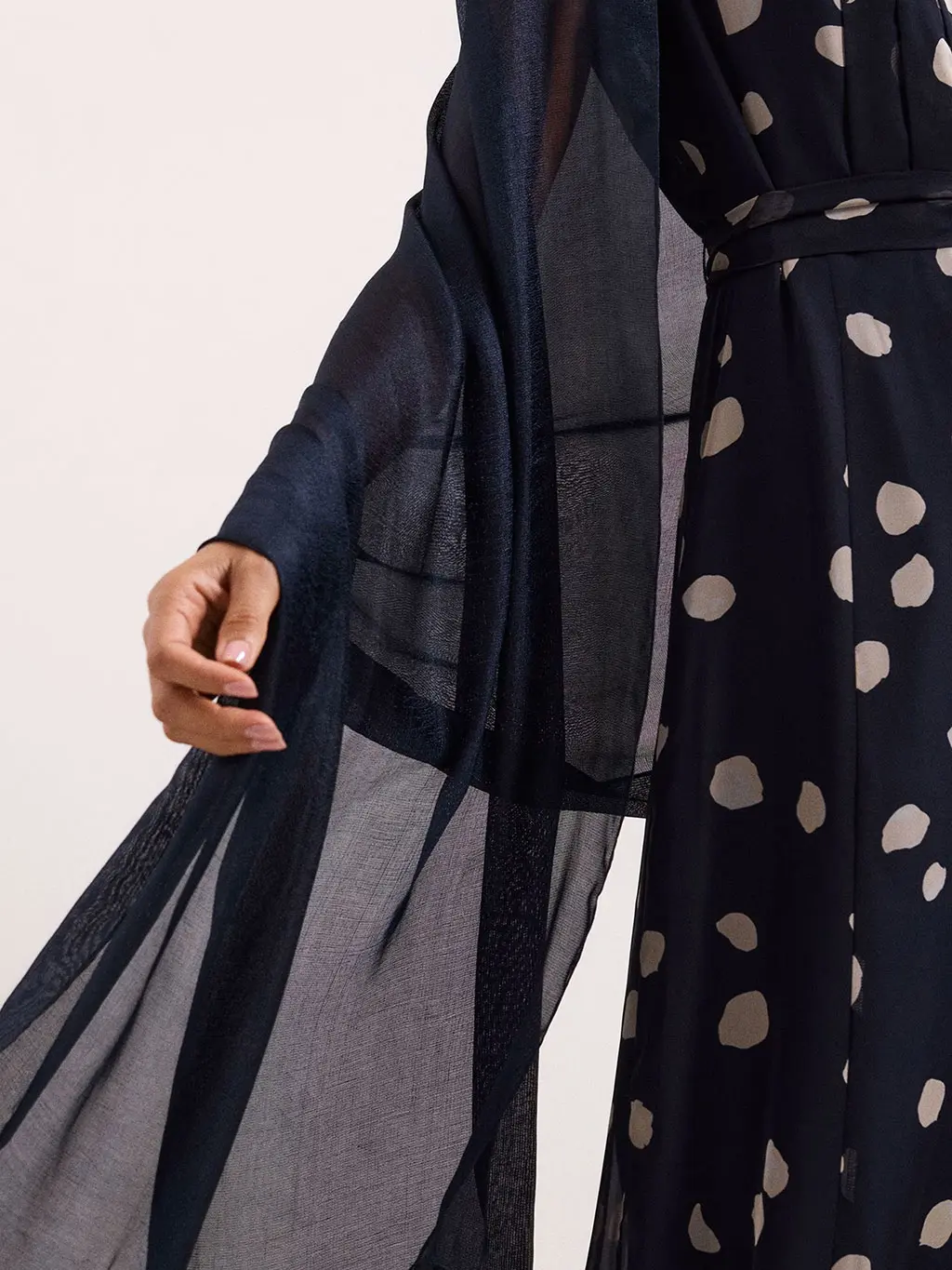 Woman wearing a navy pashmina with a polka-dot dress