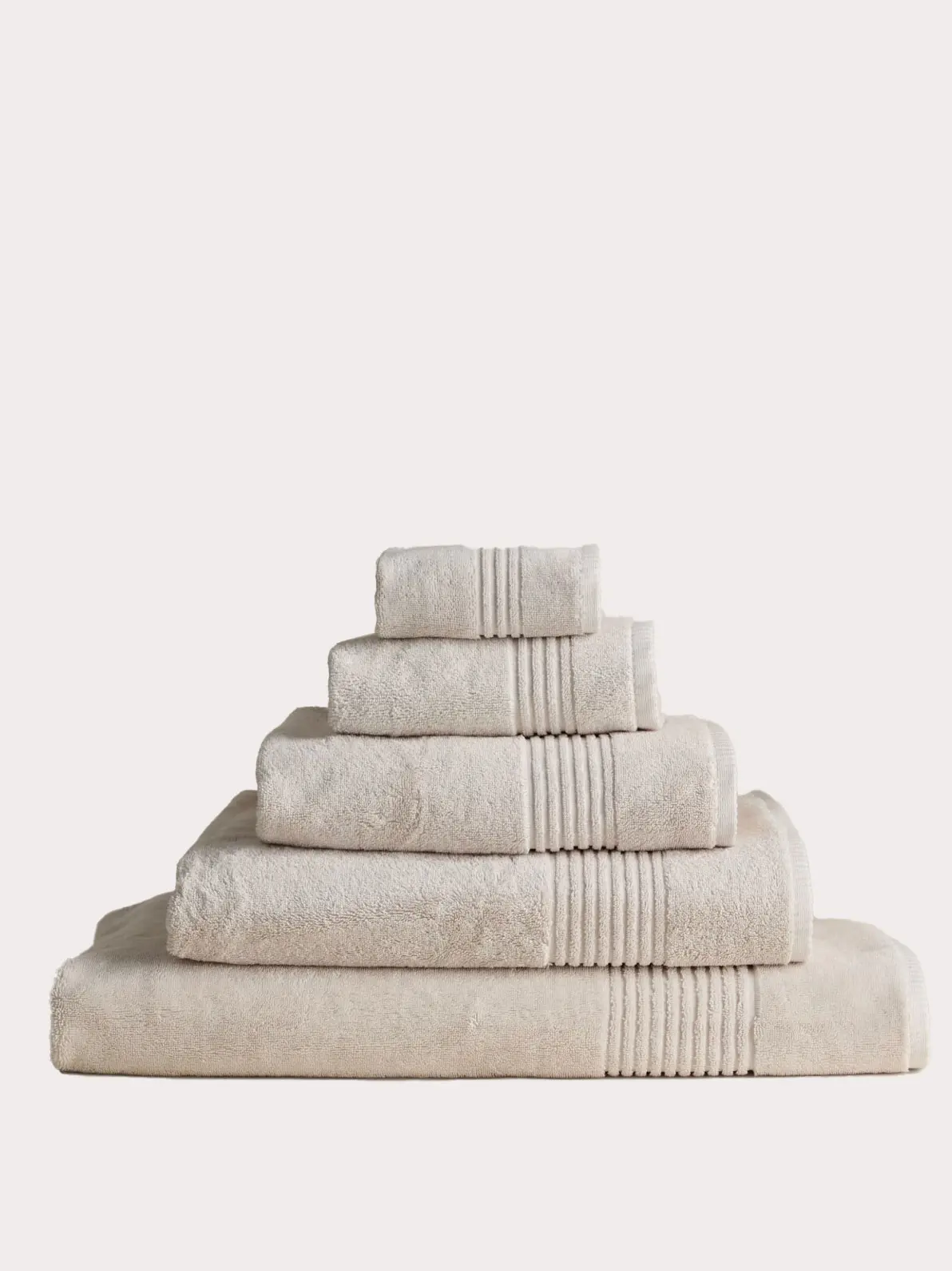 Pile of five neutral towels in an assortment of sizes
