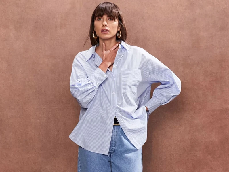 Woman wearing oversized blue shirt and jeans