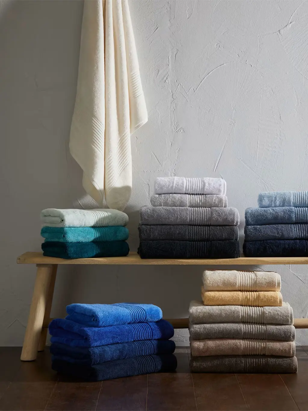 Piles of towels in different colours arranged on a bench