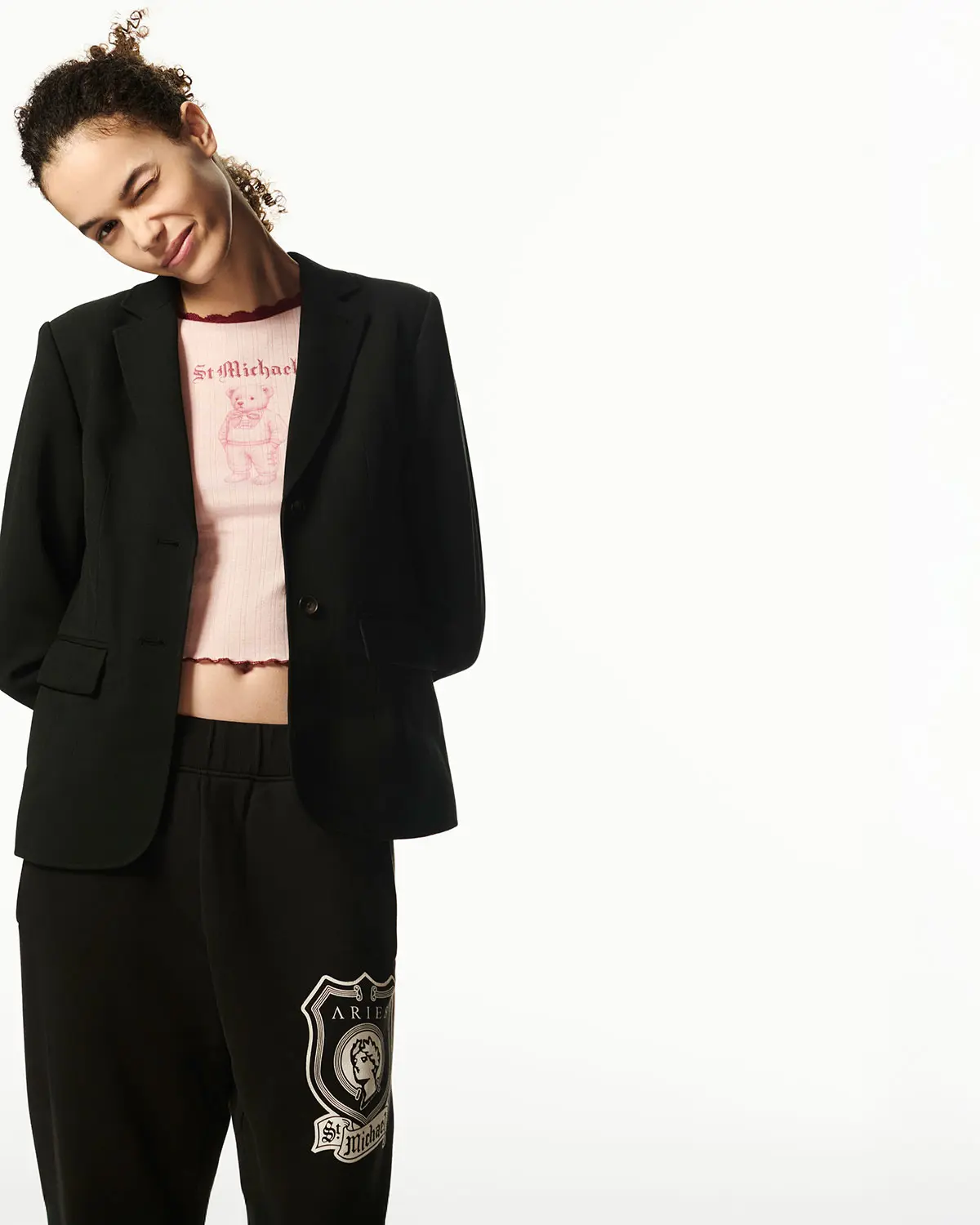 Woman wearing blazer over pink logo T-shirt