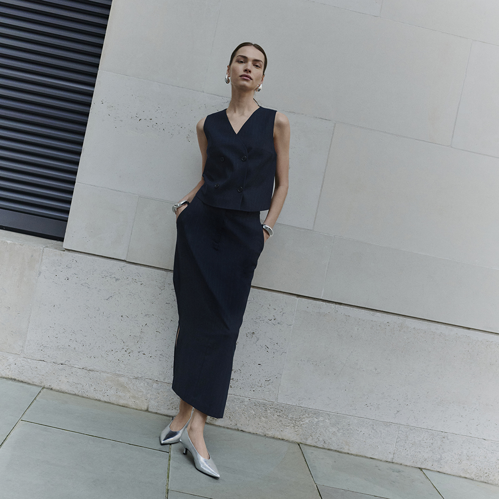 Woman wearing navy pinstripe waistcoat and maxi skirt