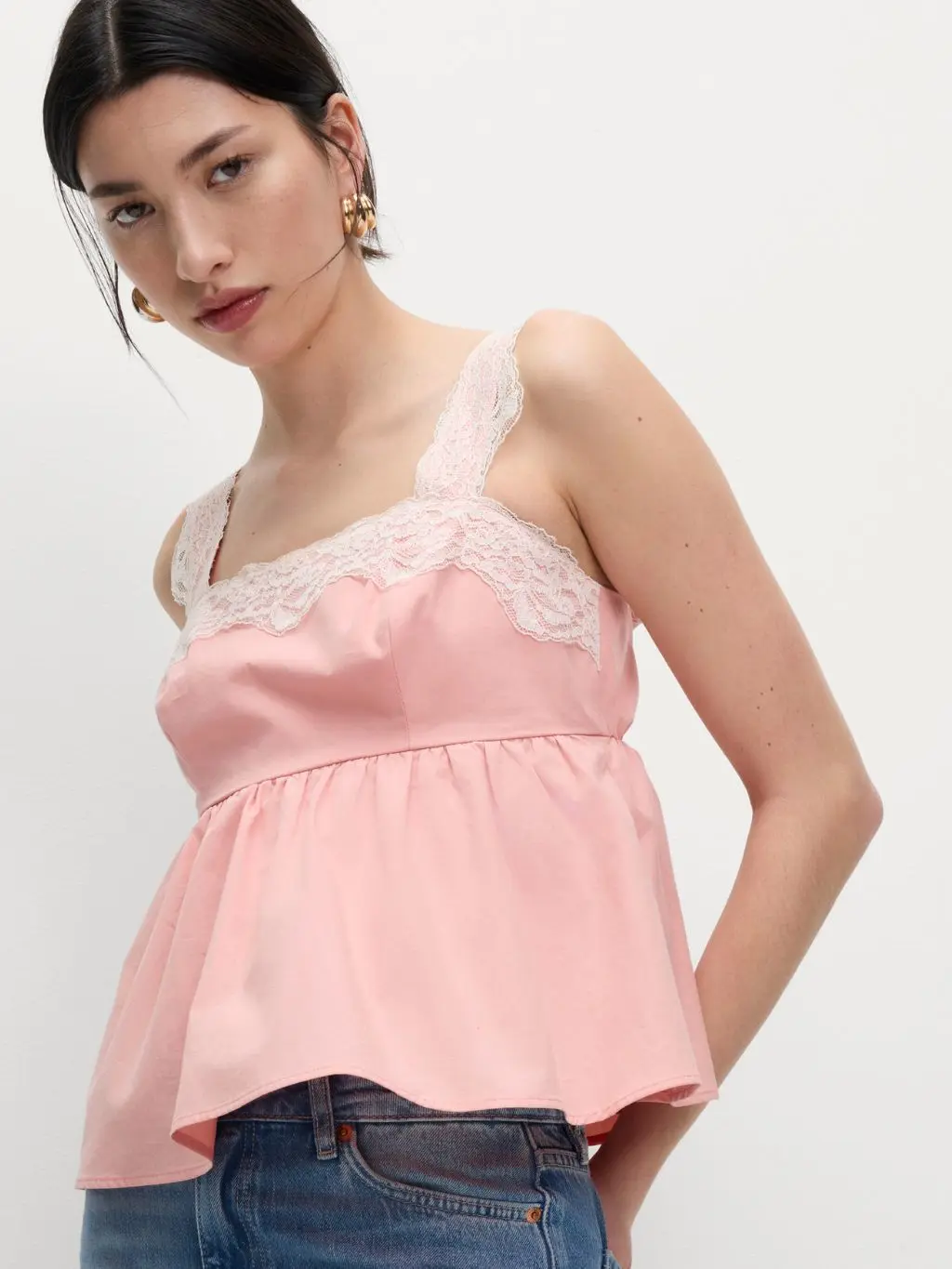 Woman wearing pink lace detail noughties cami top