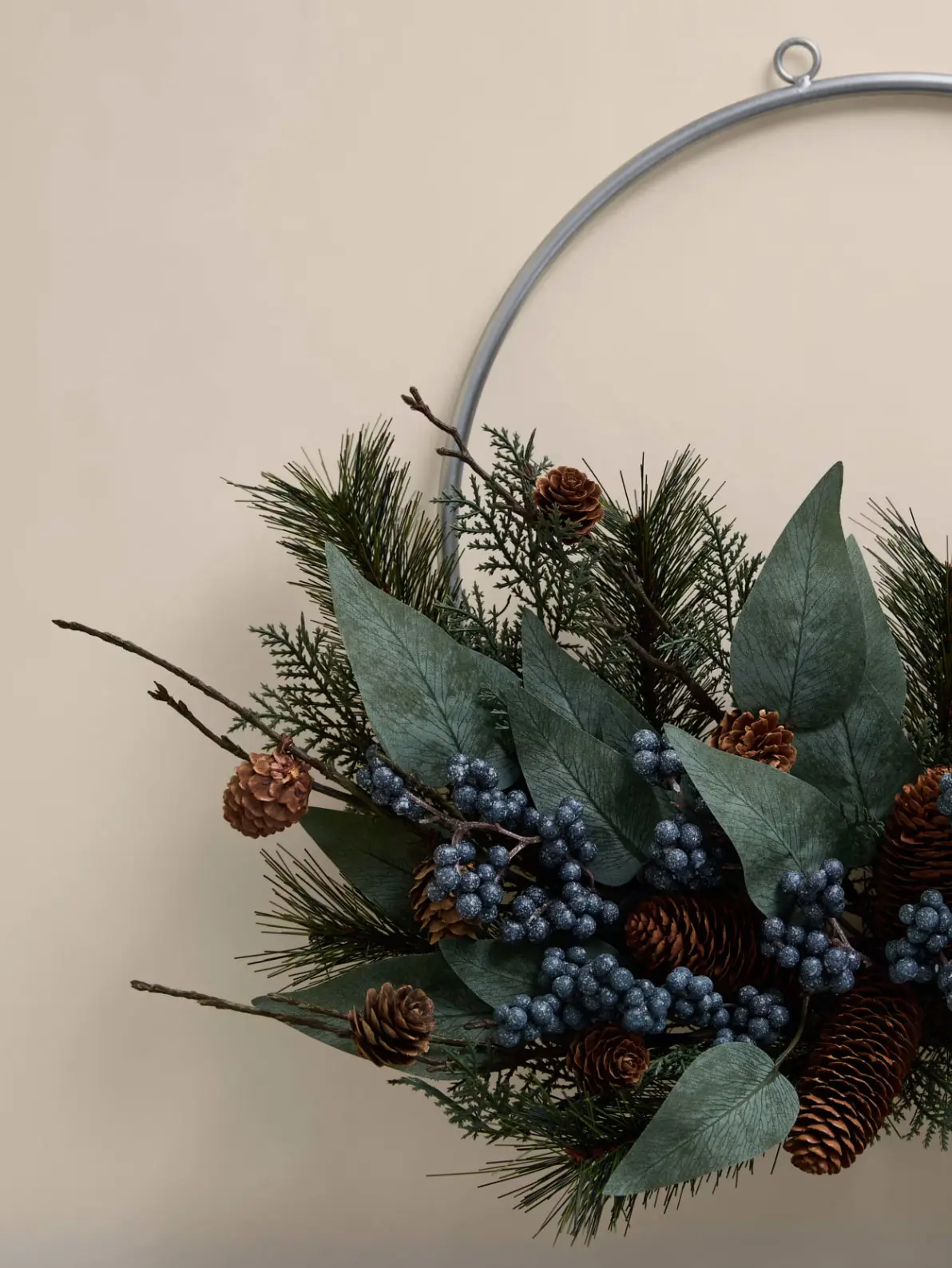 Image of festive half metal ring wreath with foliage and blue berry details