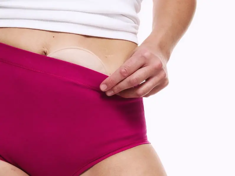 A close up of a woman wearing M&S pink stoma knickers