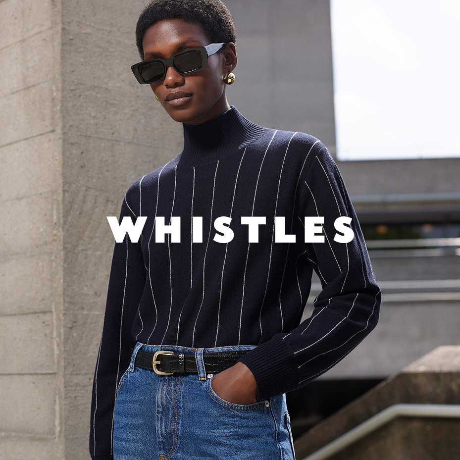 Woman wearing Whistles sunglasses, striped jumper and high-waisted blue jeans