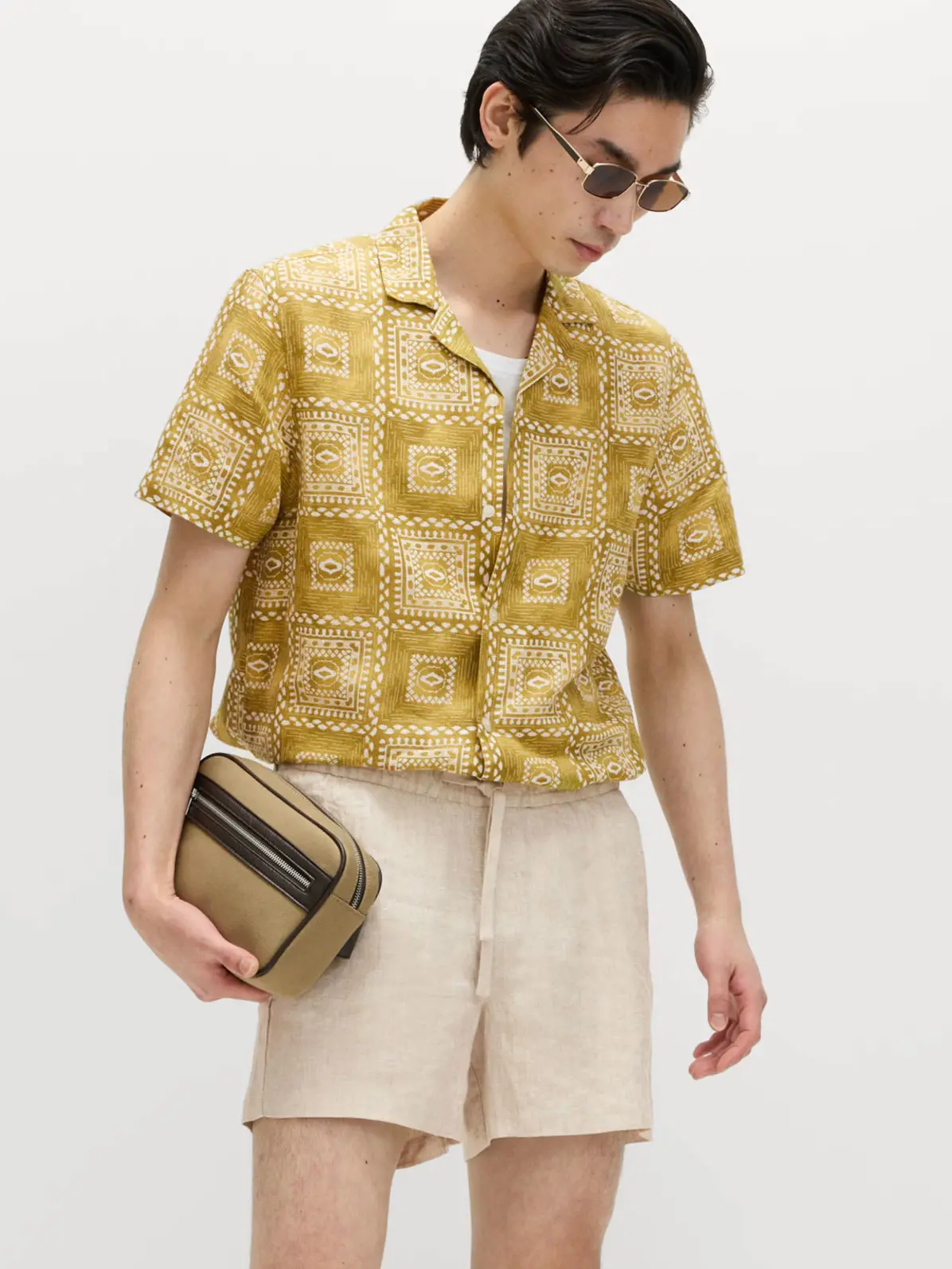 Man wearing neutral linen shorts and printed shirt