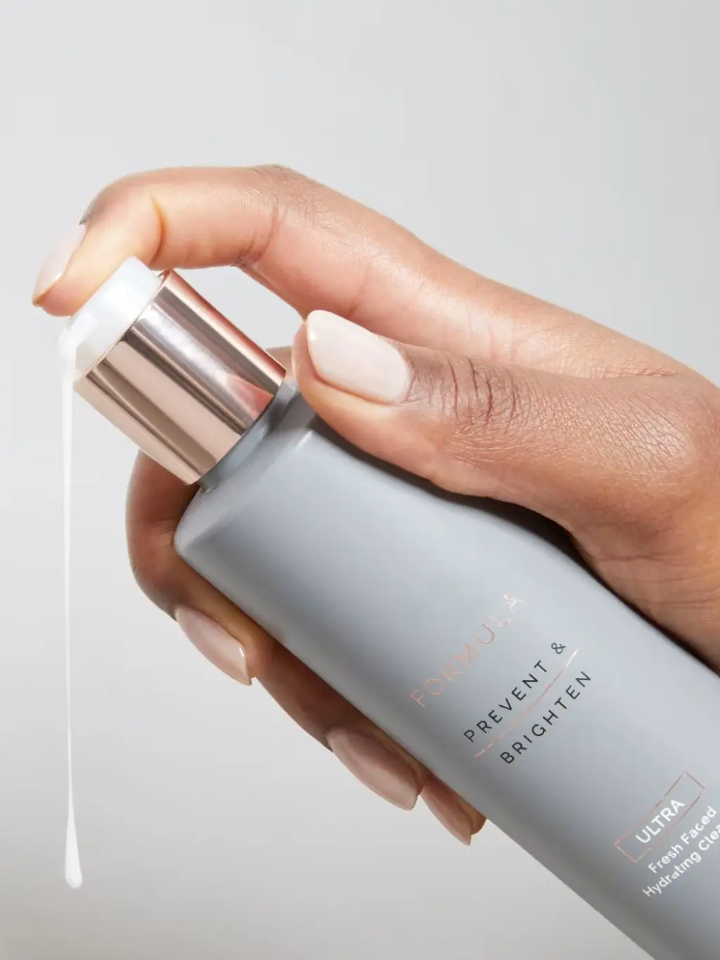 A close up of hands squirting out cream cleanser for ageing