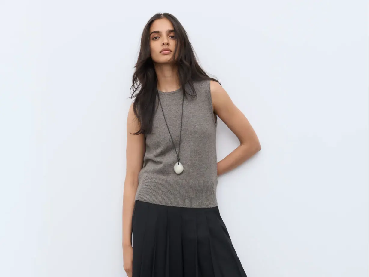 Woman wearing a knitted vest and black skirt