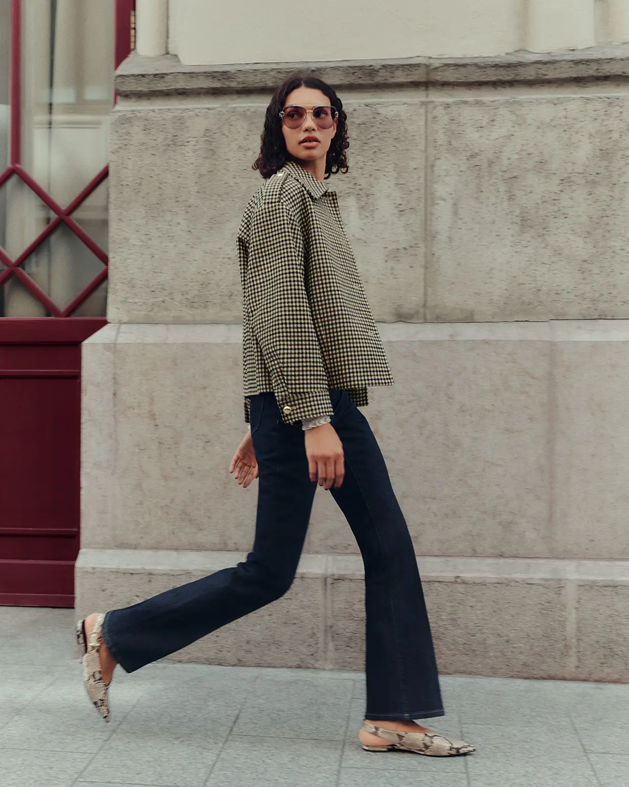 Woman wearing a checked jacket and bootcut jeans