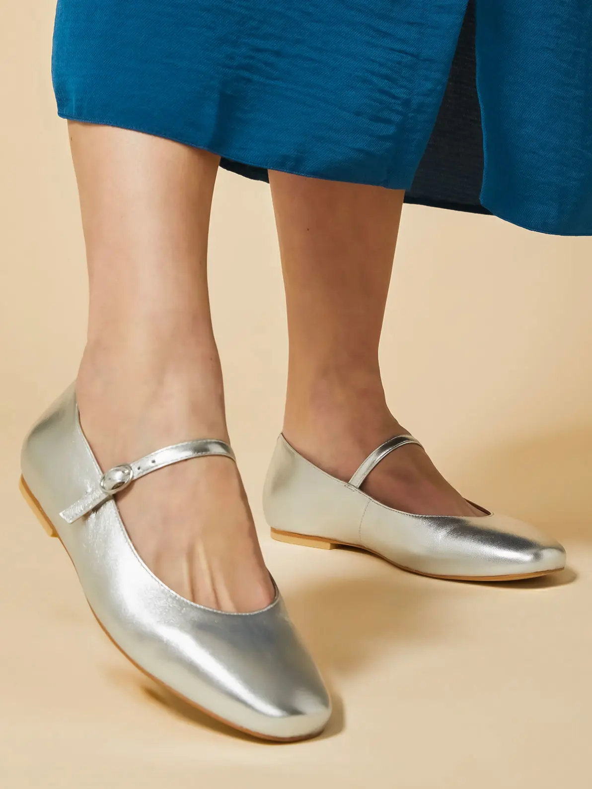 Woman wearing a pair of metallic ballet flats