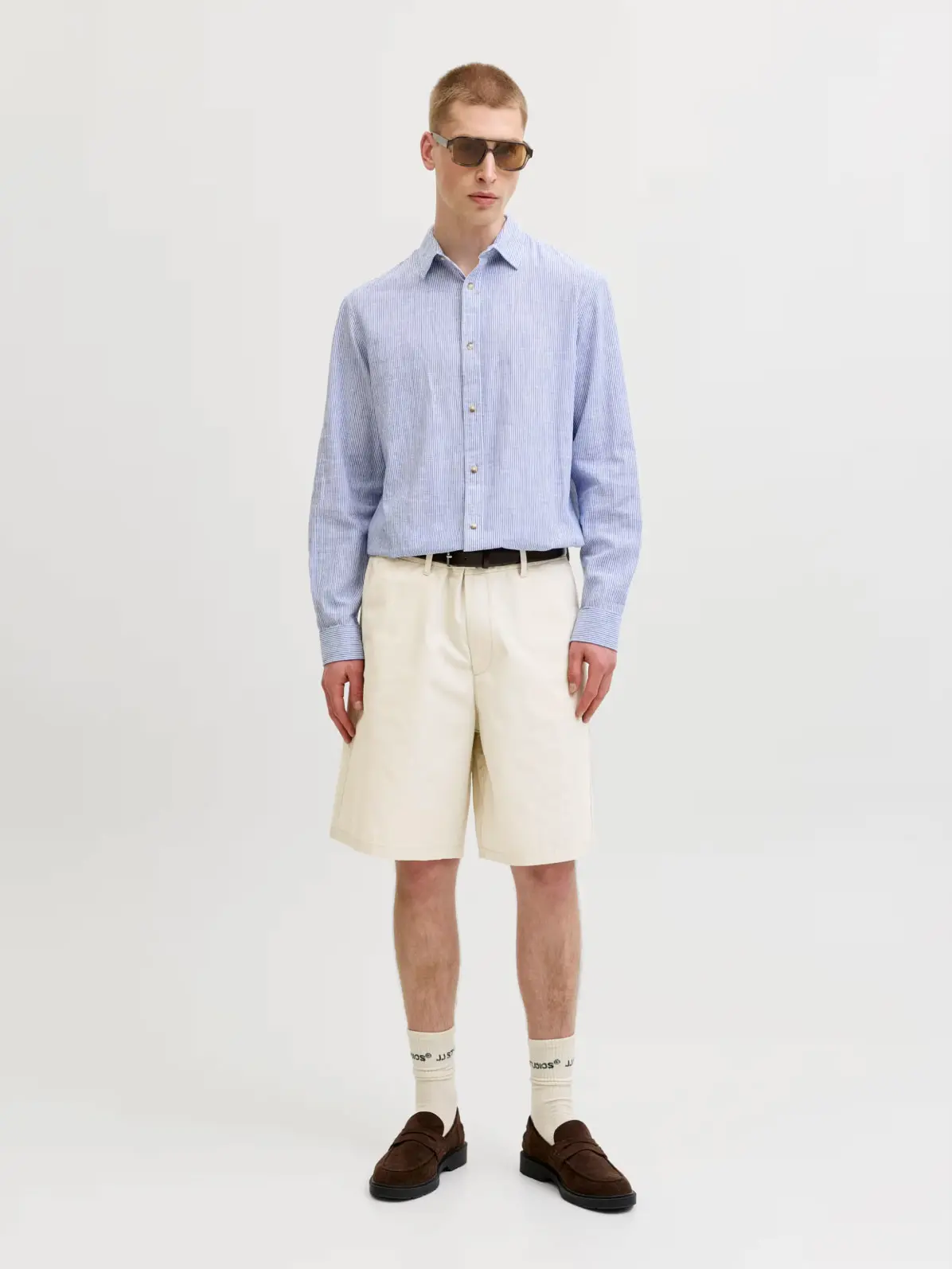 Man wearing blue shirt, tailored shorts and loafers