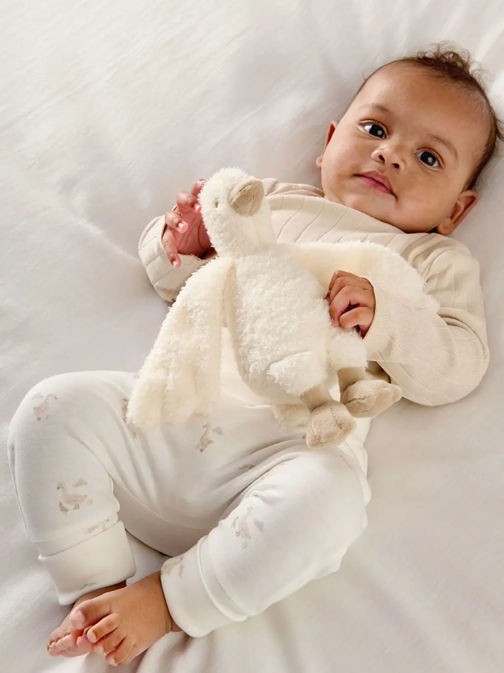 baby with duckling beanie toy
