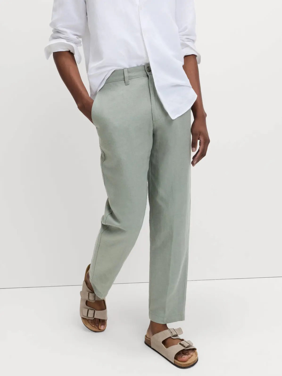 Man wearing mint green chinos, white shirt and sandals 