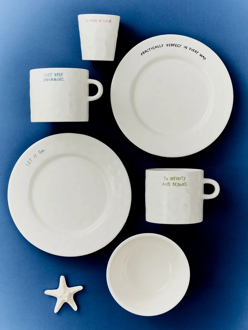 White plates, bowls and mugs on blue background