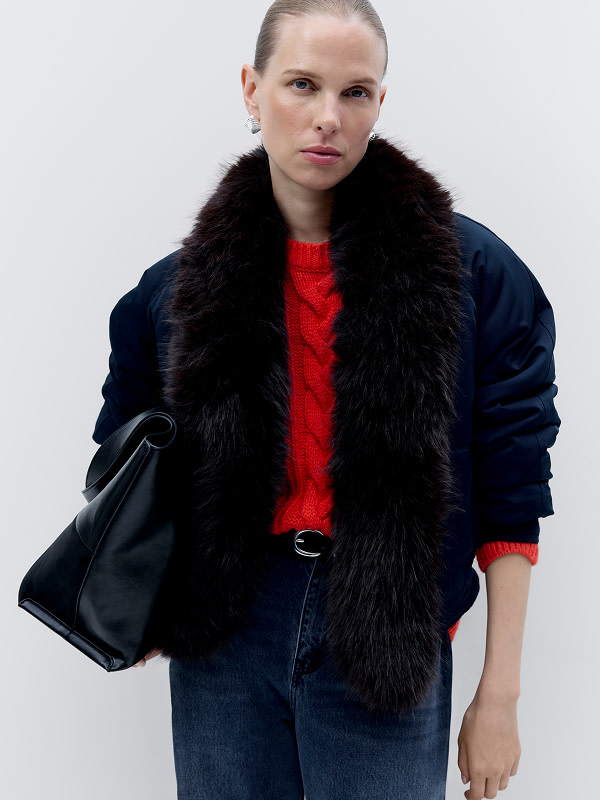 Woman wearing jacket over red jumper