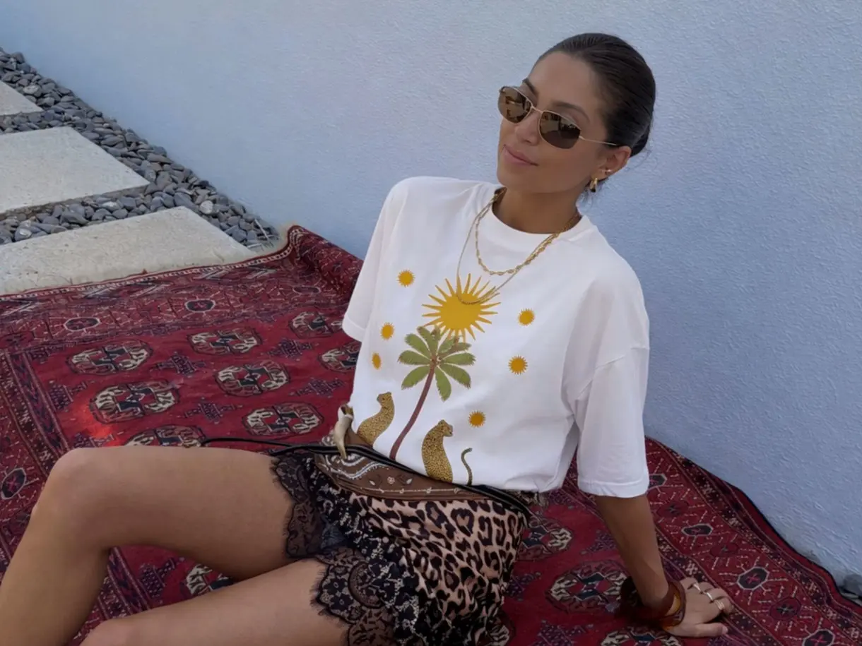 Woman wearing graphic T-shirt, animal-print mini skirt and sunglasses
