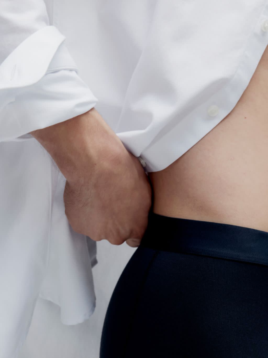 Close up of a man wearing a white shirt and black trunk underwear