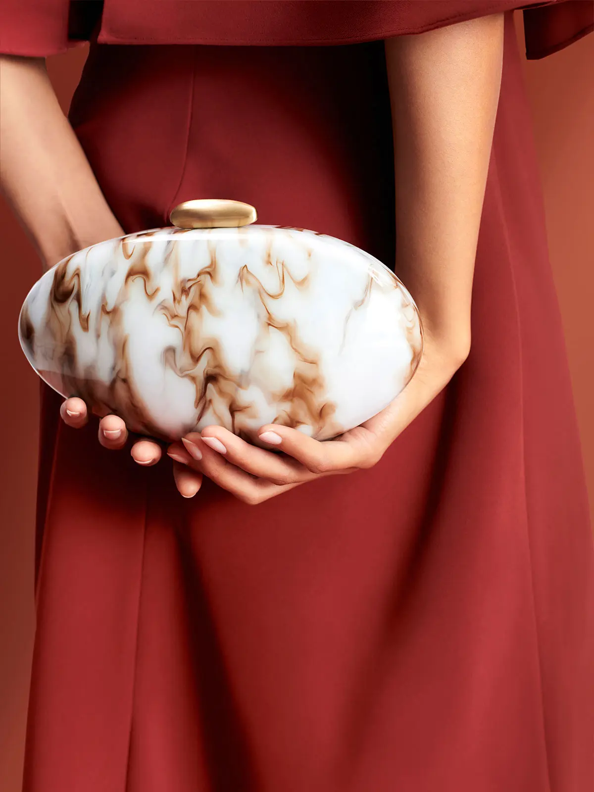 Woman holding white marble clutch bag