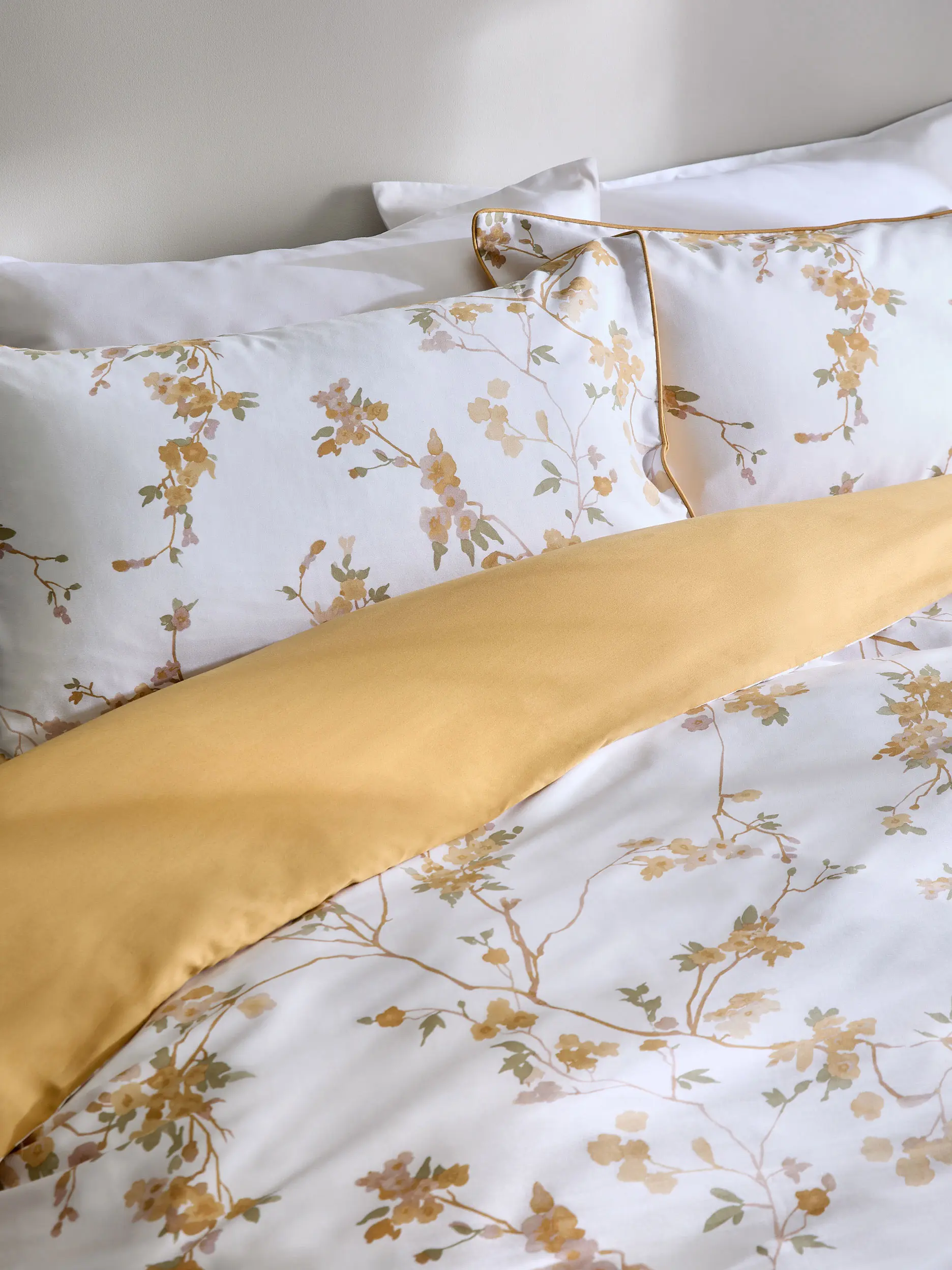 A yellow and white floral bedding set, with a yellow under side