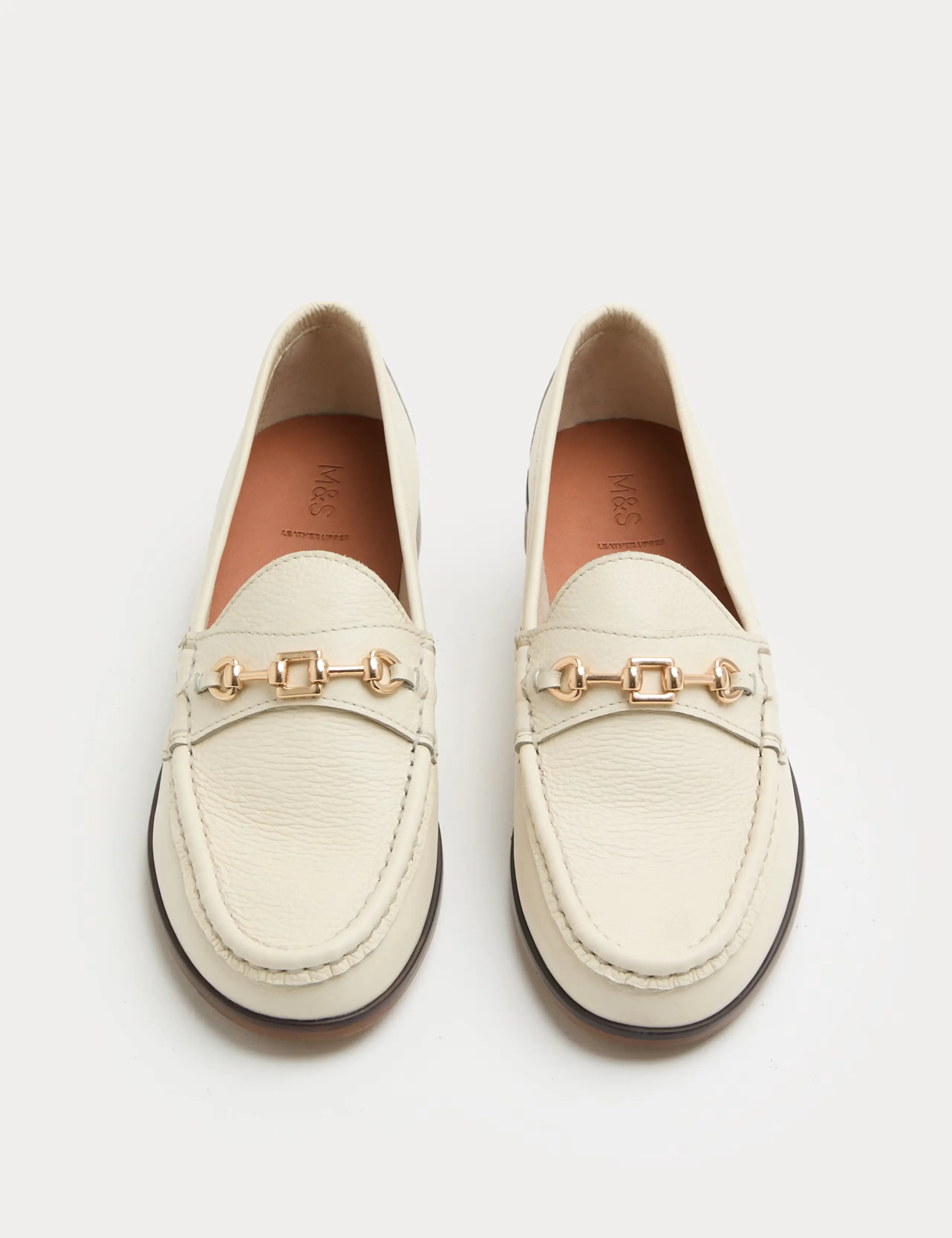 A cutout of cream leather loafers