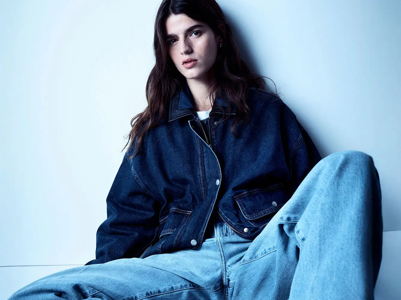 Woman wearing dark denim jacket and light wash jeans