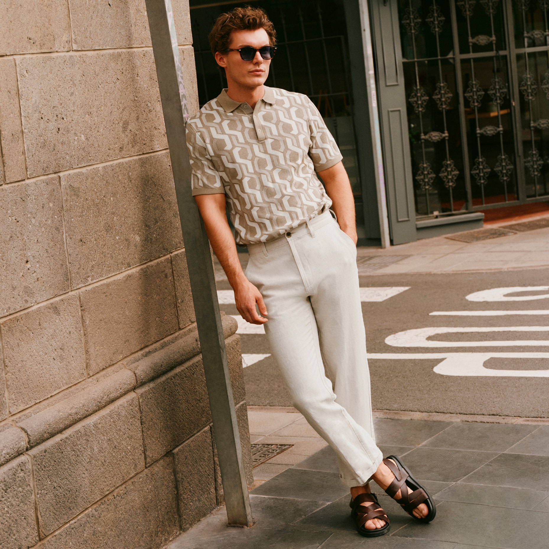 Man wearing patterned shirt and cream trousers