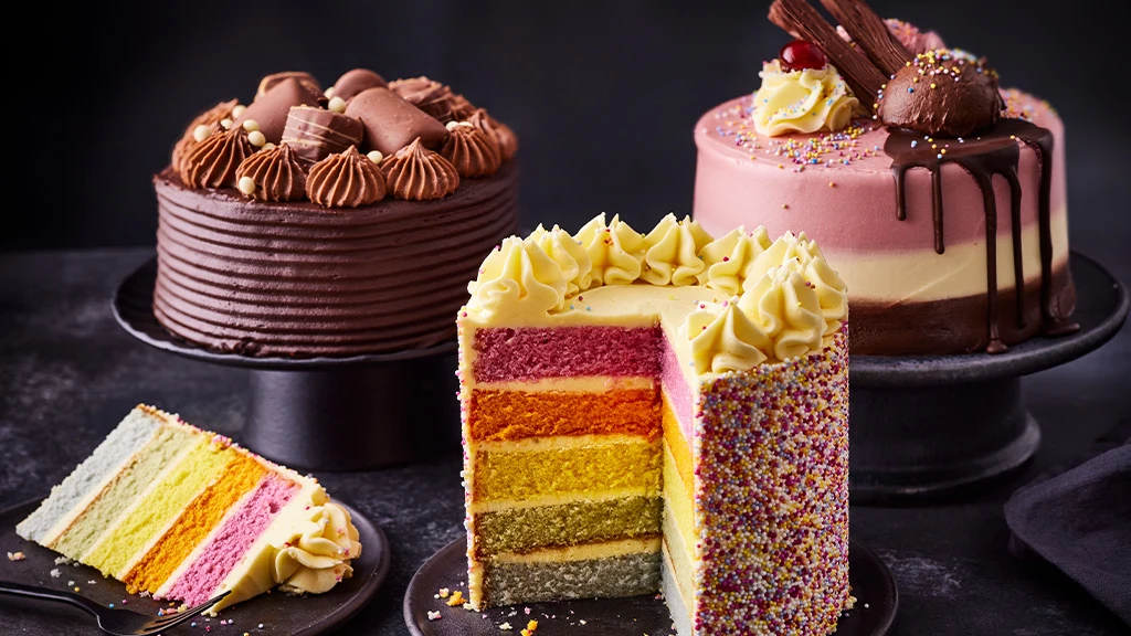 Three celebration cakes against a black background