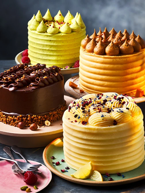 Four celebration cakes against a blue background