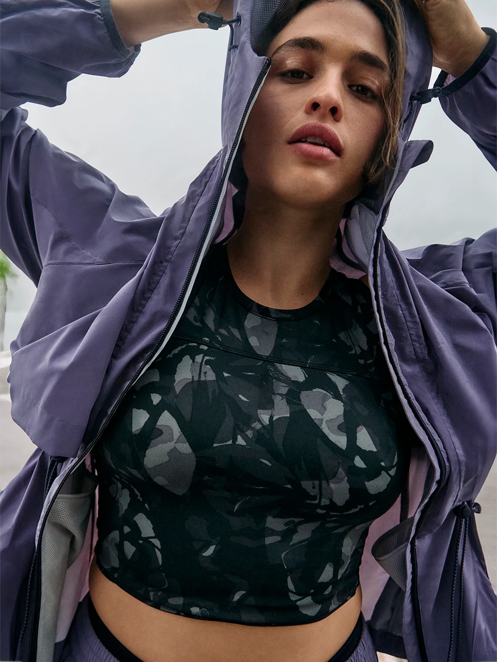 Woman wearing patterned sports bra and purple sports jacket