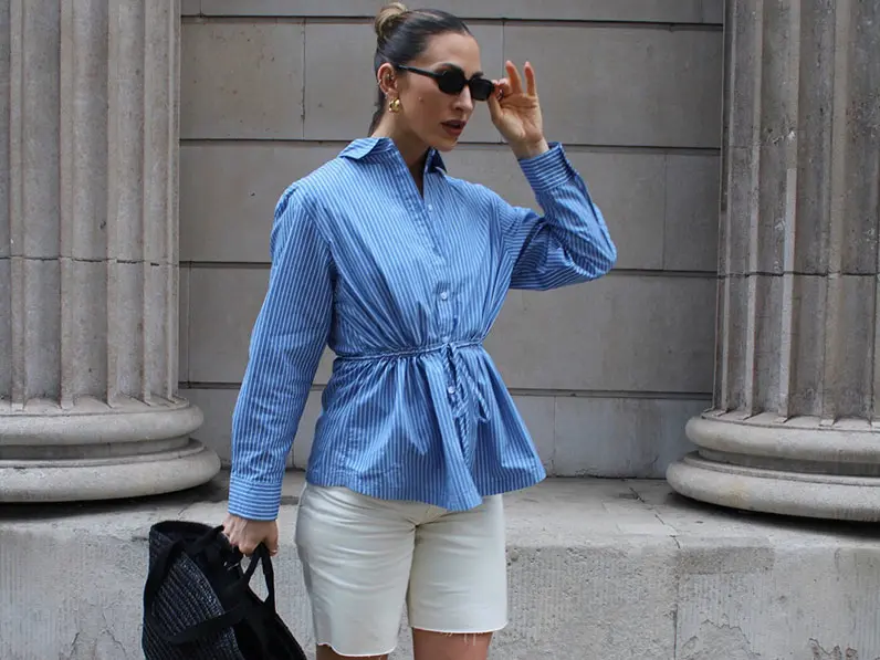 Woman in blue shirt and white shorts