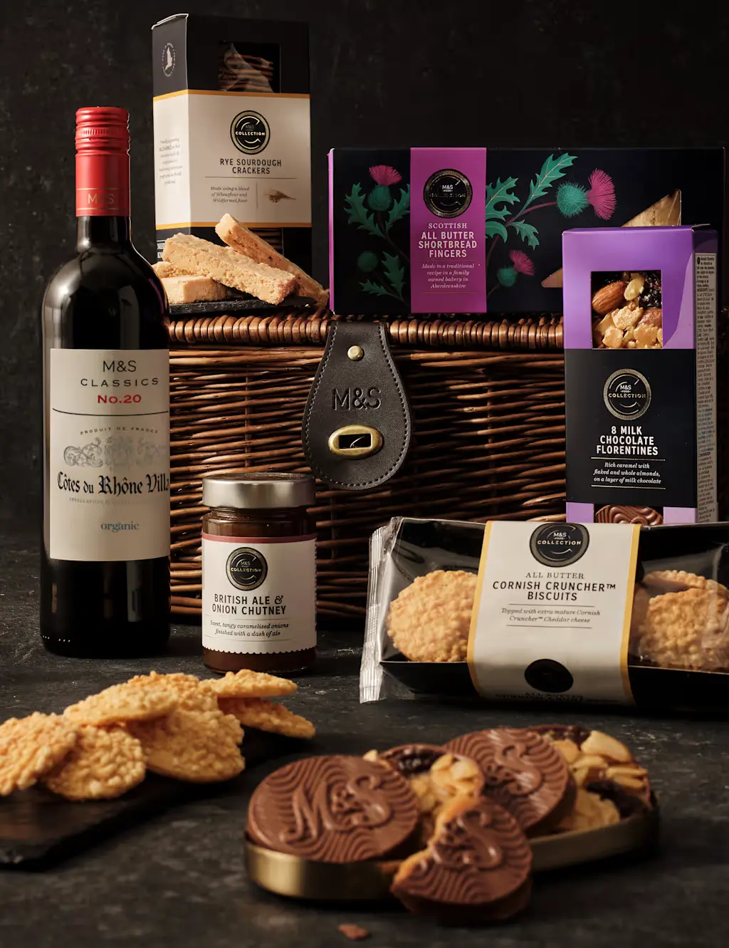 Hamper with biscuits, chocolate, wine, and crackers