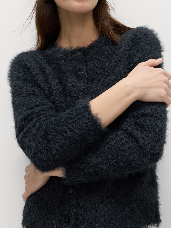 Woman wearing a navy textured crew-neck cardigan