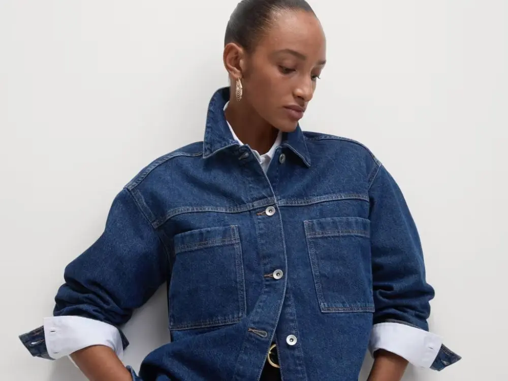 A model wearing a dark denim shacket over a white shirt