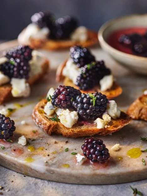 Blackberry crostini on a grey plate