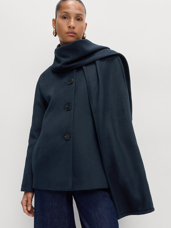 Woman wearing a navy cropped coat with detachable scarf