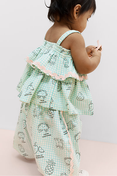 Baby wearing blue outfit with food graphics