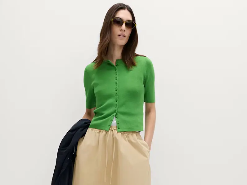 Woman in green top and tan skirt