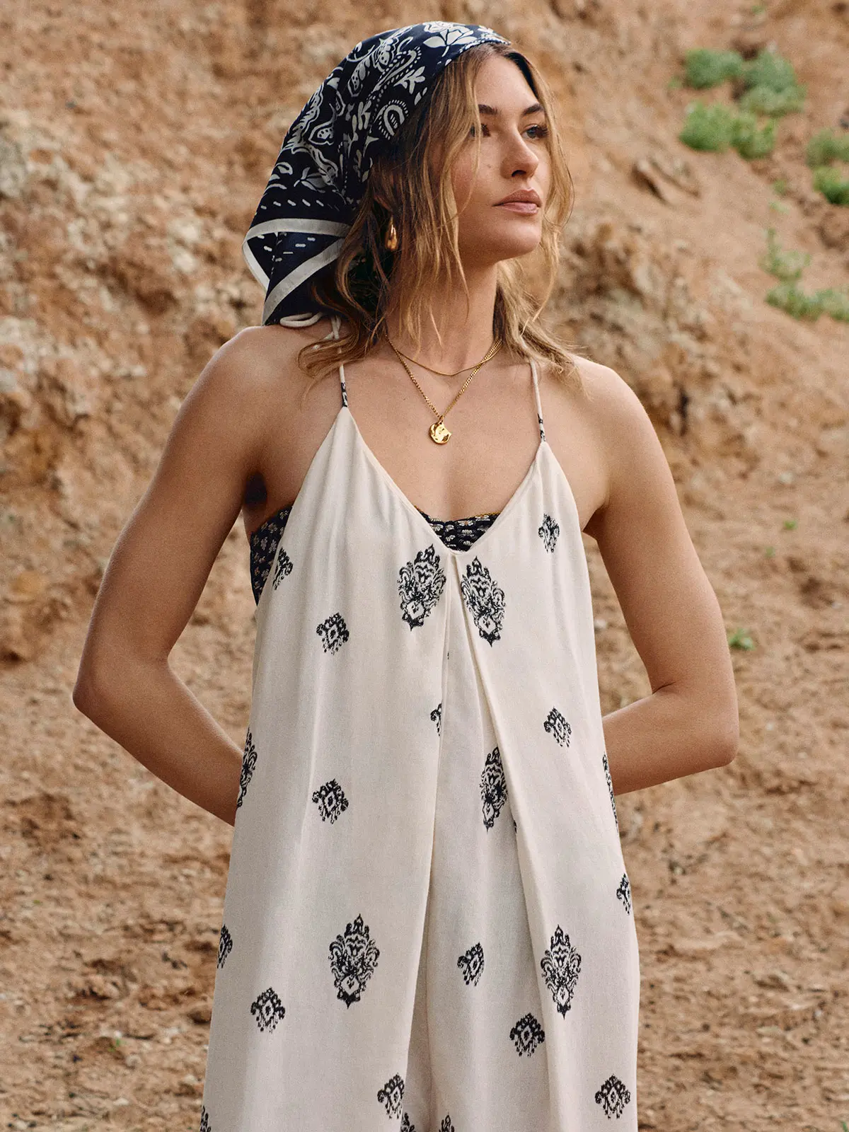 Woman wearing white printed dress and patterned headscarf 