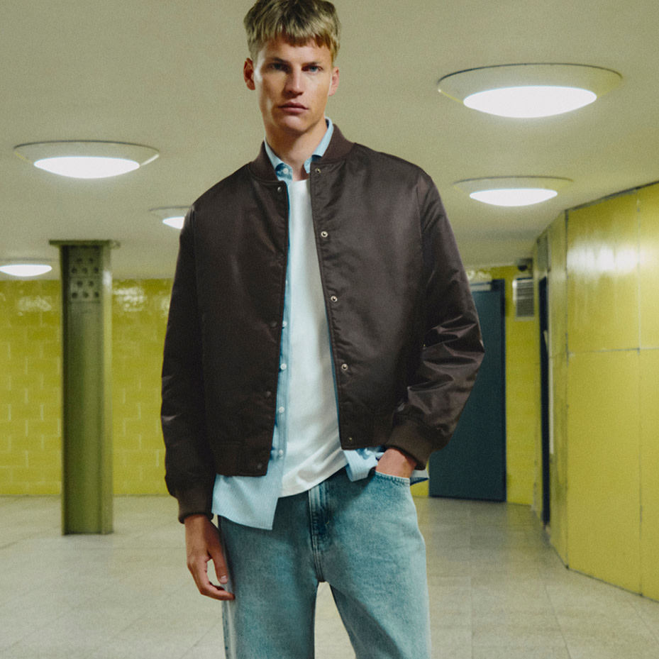 Man wearing layers over blue jeans