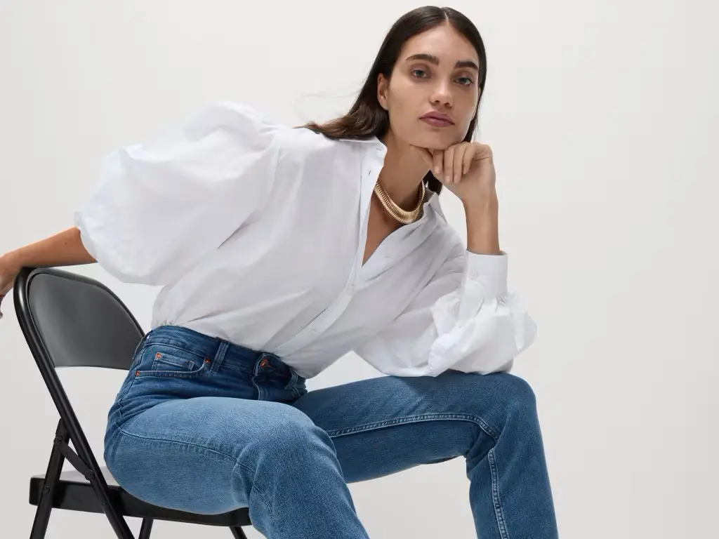 Woman wearing a white blouse and blue straight-leg jeans at M&S