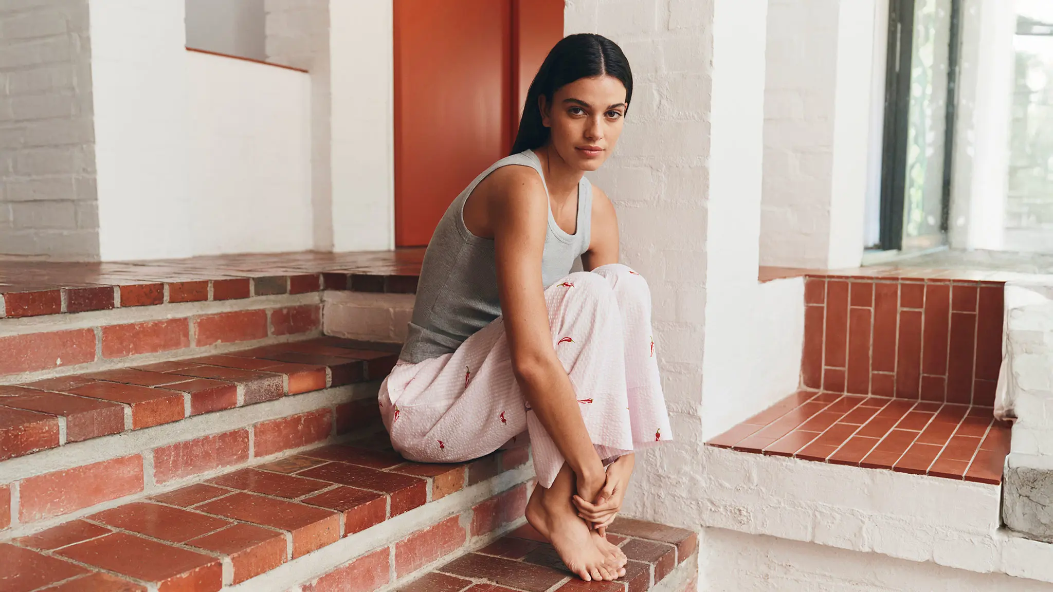 woman wearing a grey tank top and pink patterned pyjamas