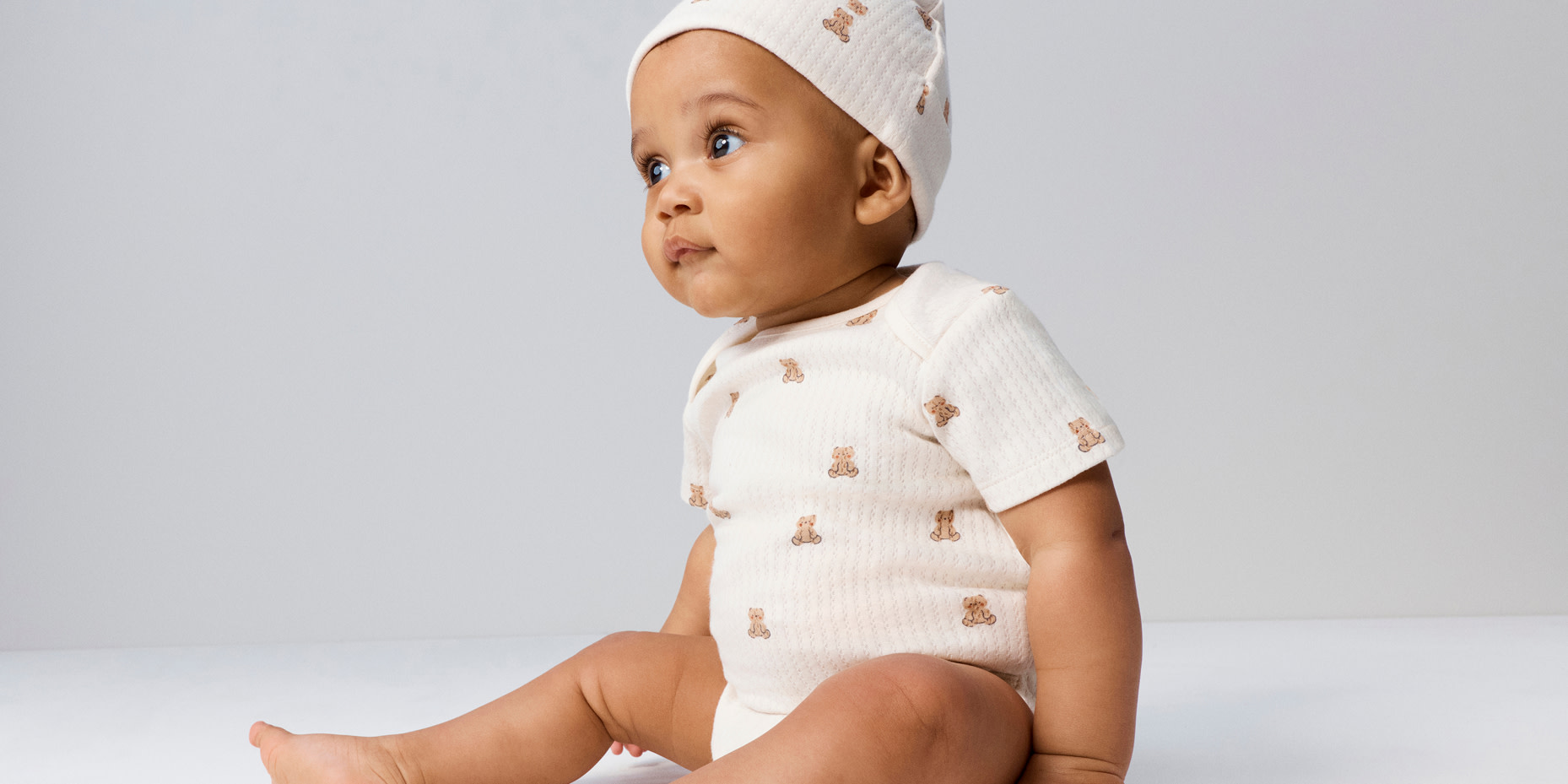 Baby in printed outfit and matching hat