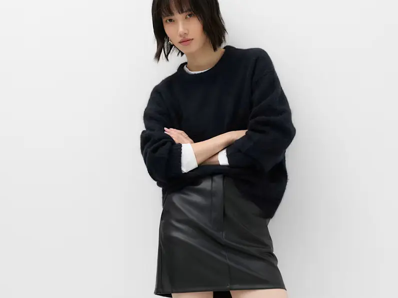 Woman in black jumper and leather skirt