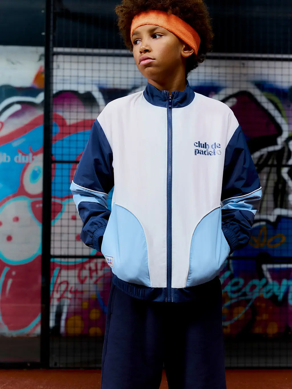 Boy wearing windbreaker and orange headband